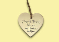 a ceramic heart hanging on a string with a message