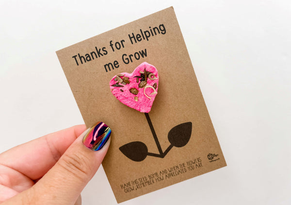 a hand holding a card with a pink flower on it