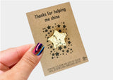 a hand holding a card with a star design on it