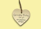 a ceramic heart hanging on a string with a message