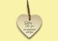 a heart shaped ceramic ornament with a saying on it