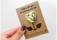 a hand holding a card with a flower on it