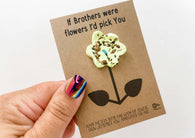 a hand holding a card with a flower on it