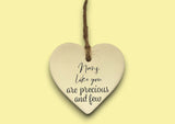 a ceramic heart hanging on a string with a message