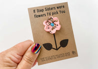 a hand holding a card with a flower on it