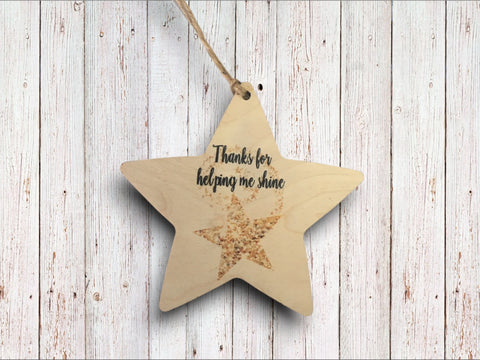 a wooden star ornament with a message on it